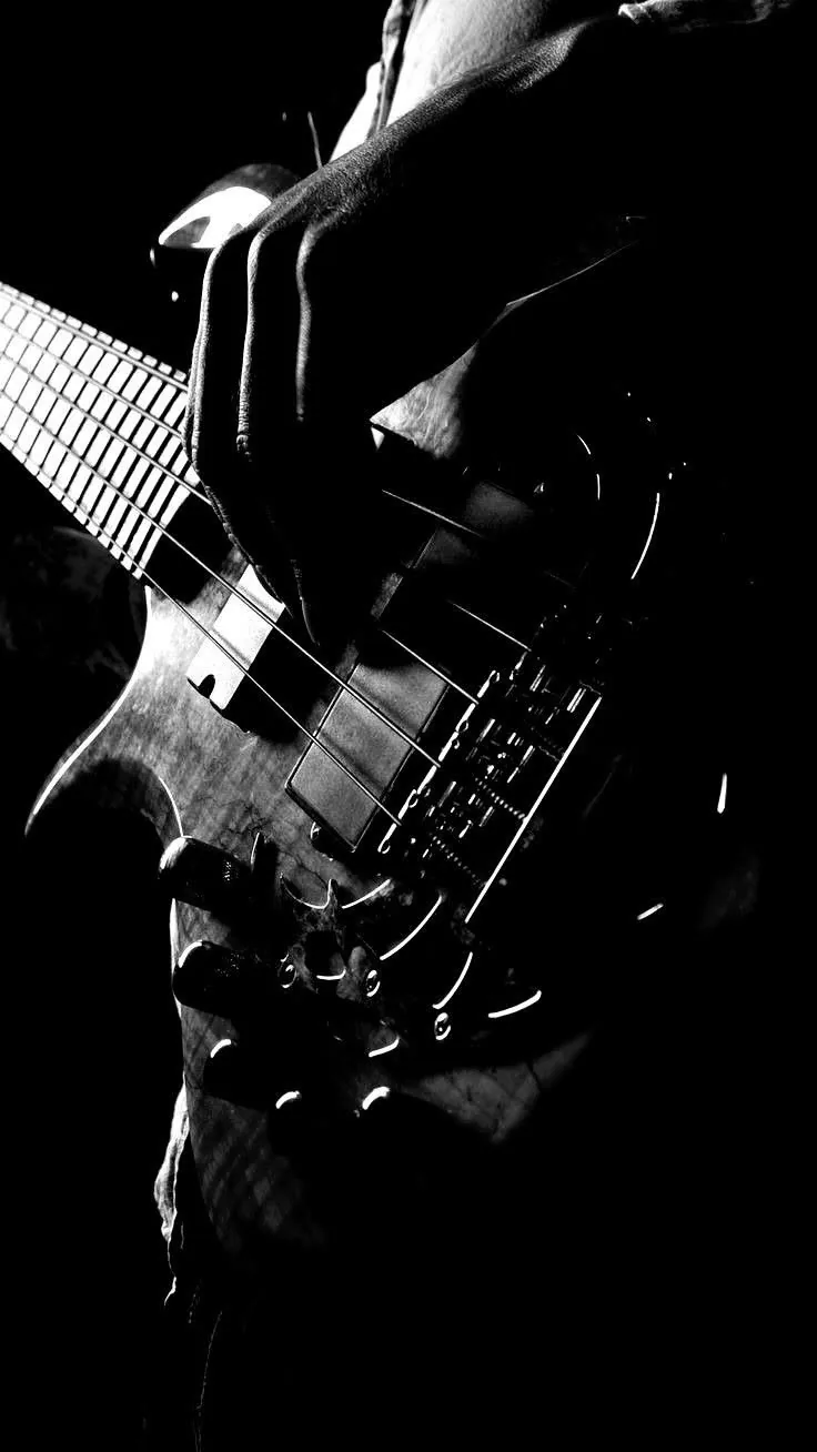 Mano tocando las cuerdas de un bajo eléctrico
